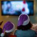 Family with purple Santa hats in front of the TV