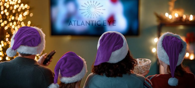 Family with purple Santa hats in front of the TV