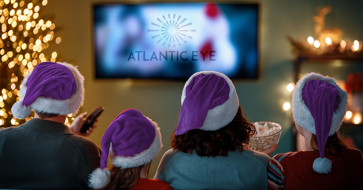 Family with purple Santa hats in front of the TV